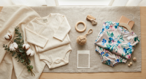 A high-quality editorial flat lay featuring a soft organic cotton onesie next to a synthetic polyest